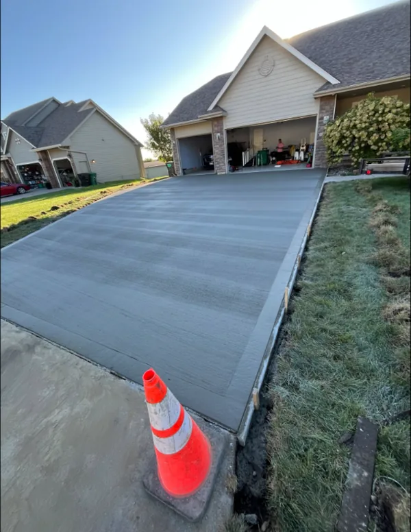 Broom-finished concrete driveway by Medina Concrete in front of a two-car garage, Des Moines