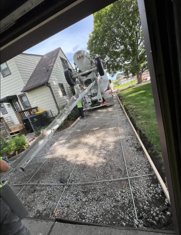 Ready-mix truck pouring concrete into a formed driveway on a Medina Concrete job